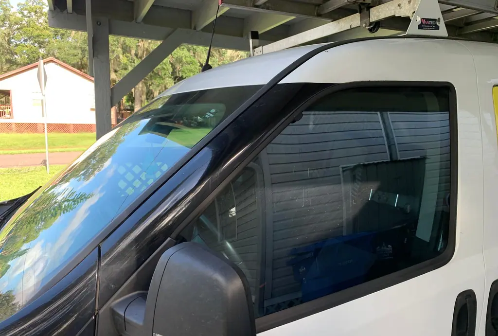 White work van with tinted door glass and a tinted strip across the top of the windshield